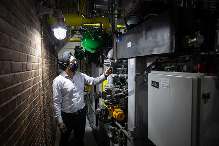 The Chief Operating Engineer and Manager of the Central Steam Plant examines part of the plant.