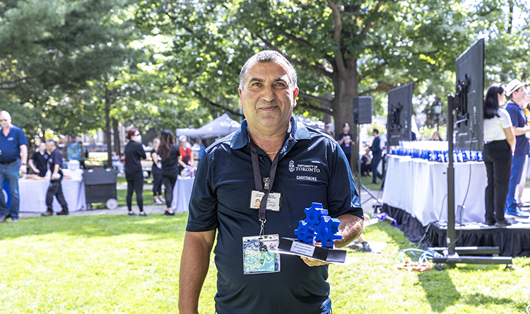 Carlos stands, holding his OREP award.