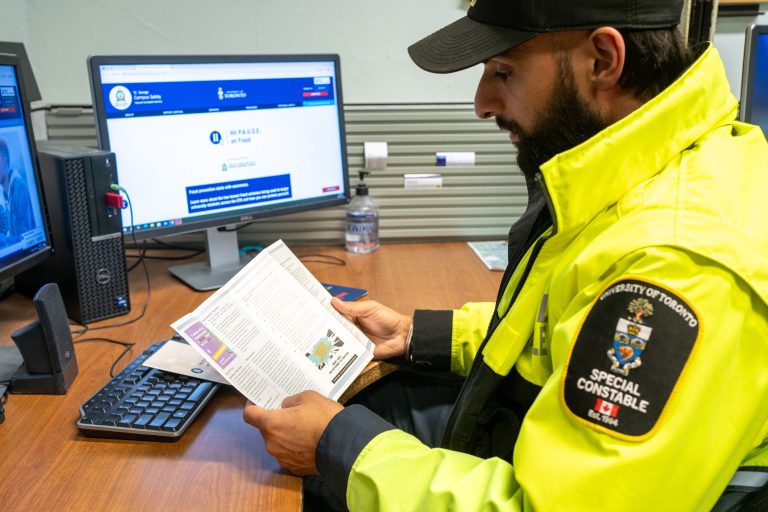 Campus Safety Special Constable Aj Gill reviewing a fraud brochure.